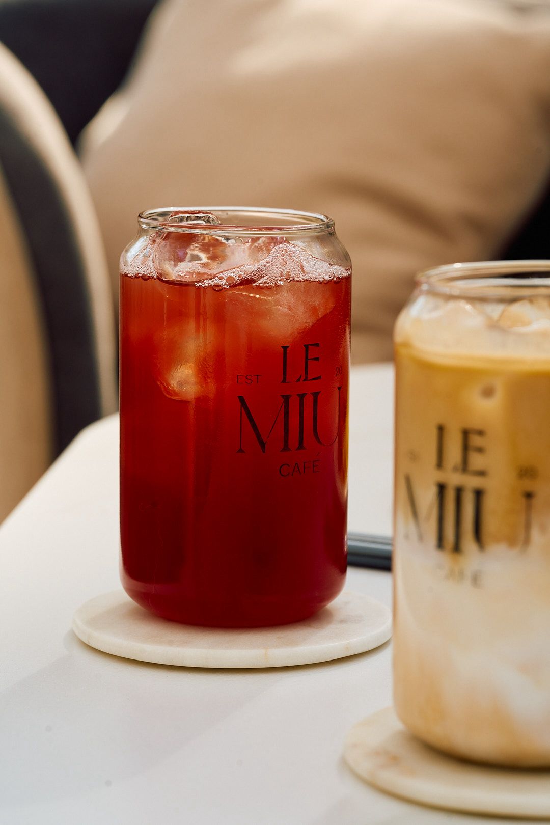 Two branded glassware cups, one berry-hibiscus, one iced latte